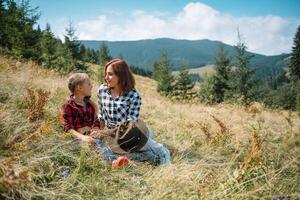 mamma abbracci un' poco figlio a il superiore di il montagna. quadrato. il concetto di famiglia, yoga, viaggio. foto