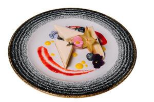 torta di formaggio con marmellata e frutti di bosco su un' piatto su un' bianca sfondo. foto
