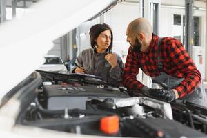 auto auto riparazione servizio centro. meccanico l'esame auto motore. femmina meccanico Lavorando nel sua officina. auto servizio attività commerciale concetto. professionista auto femmina meccanico assunzione cura di veicolo. foto