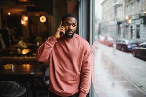 maturo africano americano uomo parlando di Telefono nel bar. foto