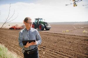 contadino su sfondo di trattore semina campo. opera nel il campo. agricoltura concetto. azienda agricola opera nel il campo nel primavera foto