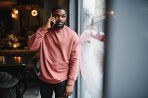 maturo africano americano uomo parlando di Telefono nel bar. foto