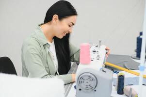 bella giovane donna che cuce vestiti con macchina da cucire. foto