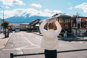 donna turista con fuji montagna a Kawaguchiko treno stazione, contento viaggiatore giro turistico montare fuji nel yamanashi, Giappone. punto di riferimento per turisti attrazione. Giappone viaggiare, destinazione e vacanza foto