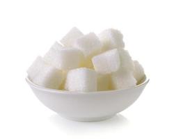 Zollette di zucchero in una ciotola isolata su sfondo bianco foto