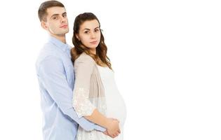 felice coppia di innamorati in attesa della nascita del bambino in posa su uno sfondo bianco