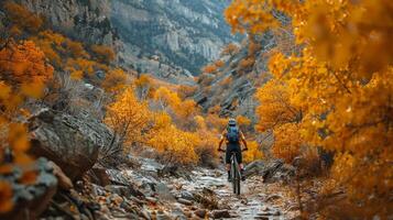 ai generato ciclista equitazione attraverso un' aspro montagna sentiero, con vivace autunno fogliame la creazione di foto