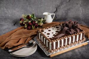 piazza cioccolato torta con rosa fiori, cucchiaio e forchetta servito su tavola isolato su tovagliolo lato Visualizza di bar al forno cibo foto