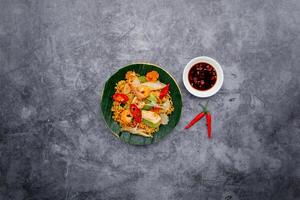 frutti di mare gamberetto fritte spaghetto con insalata e pesce salsa servito nel ciotola isolato su buio grigio sfondo superiore Visualizza di giapponese cibo foto