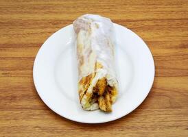 Arabo pollo shawarma rotolo avvolgere servito nel un' piatto isolato su grigio sfondo lato Visualizza di indiano, pakistano cibo foto