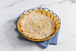 punjabi prima colazione naan kulcha nel un' cestino isolato su tovagliolo lato Visualizza su grigio sfondo famoso indiano e pakistano cibo foto