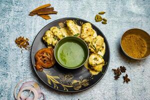 pollo reshmi tikka boti kabab con fuso burro e chili salsa servito nel un' piatto isolato su grigio sfondo superiore Visualizza di bangladesh cibo foto