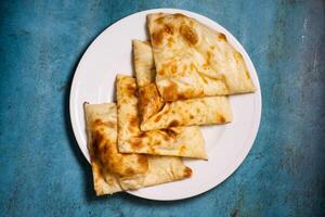 croccante paratha affettato servito nel un' piatto isolato su sfondo superiore Visualizza di pakistano cibo foto