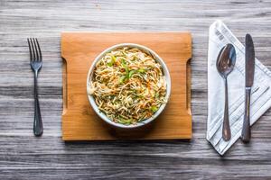 hakka tagliatelle verdure con cucchiaio e fazzoletto di carta isolato su di legno tavola superiore Visualizza su tavolo Fast food foto