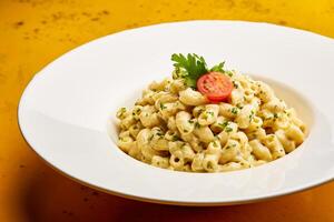 Mac e formaggio maccheroni con basilico e pomodoro servito nel piatto isolato su tavolo superiore Visualizza di Arabo gustoso fastfood foto