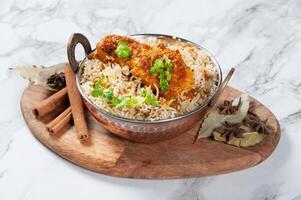 indiano speziato burro pollo satay biryani servito nel un' piatto isolato su di legno tavola lato Visualizza su grigio sfondo foto