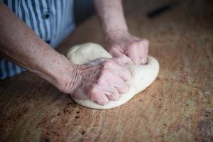 tipico dolce natalizio asturiano. mani di donna anziana che impastano la farina con l'acqua, le uova e il sale per ottenere l'impasto per le casadielles. foto