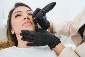 salutare terme giovane bellissimo donna avendo permanente trucco su sua labbra. avvicinamento foto