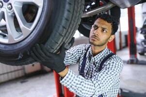 servizio, riparazione e professione concetto - indiano meccanico a auto servizio foto