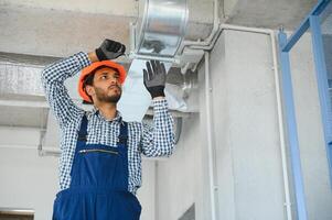HVAC indiano lavoratore installare canalizzato tubo sistema per ventilazione e aria condizionata. copia spazio foto