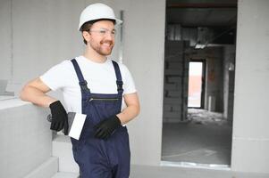 ritratto di positivo, bello giovane maschio costruttore nel difficile cappello. foto