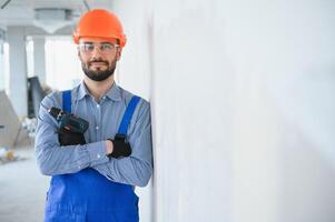 ritratto di giovane e laborioso costruttore in posa nel grande incompiuto camera. edificio concetto foto