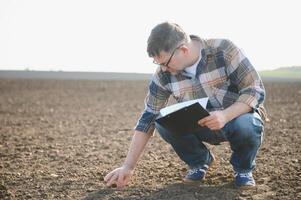 un' contadino controlli qualità di suolo prima semina. foto