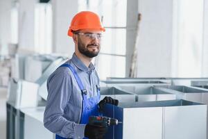 industriale tema. magazzino riscaldamento e raffreddamento sistema installazione di professionale caucasico tecnico. commerciale edificio ventilazione rettangolo canali. aria distribuzione. foto