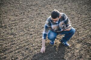 un' contadino controlli qualità di suolo prima semina. foto