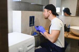 professionale idraulico Lavorando con gabinetto ciotola nel bagno foto