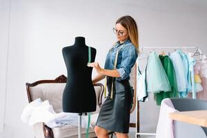 non posso rendere qualunque errore. femmina moda progettista lavori su il nuovo Abiti nel il officina. foto