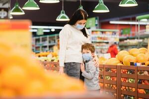 madre e bambino nel supermercato insieme, essi partire shopping liberamente senza un' maschera dopo quarantena, scegliere cibo insieme. foto