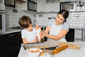 contento madre e poco figlio nel il cucina, contento tempo e solidarieta foto