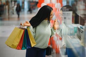 bellissimo africano americano donna Tenere multicolore shopping borse nel un' memorizzare foto