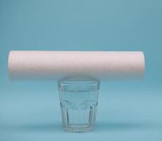 acqua filtri. carbonio cartucce e un' bicchiere su un' blu sfondo. domestico filtrazione sistema. foto