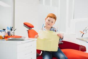 ragazzo soddisfatto con il servizio nel il dentale ufficio. concetto di pediatrico dentale trattamento foto