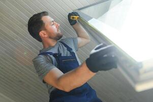 un' lavoratore installa finestre nel un' nuovo componibile casa. il concetto di un' nuovo casa. foto