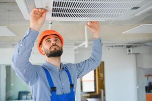 tecnico servizio controllo e riparazione aria condizionatore in casa foto