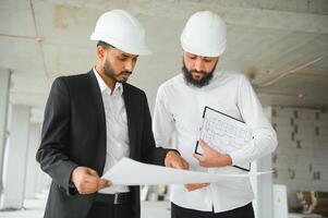 multietnico attività commerciale squadra. costruzione concetto. indiano e arabo ingegneri ispezionare il costruzione. foto
