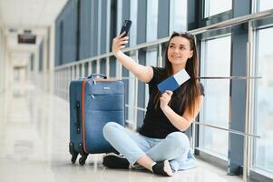 bella donna in attesa per sua volo a aeroporto foto