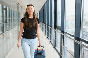 turismo, vacanza, vacanza, infanzia e mezzi di trasporto concetto - sorridente poco ragazza con viaggio Borsa al di sopra di aeroporto sfondo foto