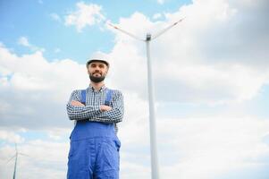 maschio ingegnere Lavorando con Piano ispezionando o Manutenzione di vento turbine a mulino a vento campo azienda agricola. foto