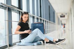 turismo, vacanza, vacanza, infanzia e mezzi di trasporto concetto - sorridente poco ragazza con viaggio Borsa al di sopra di aeroporto sfondo foto