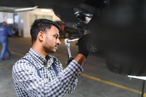 servizio, riparazione e professione concetto - indiano meccanico a auto servizio foto