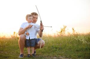 un' padre insegnamento il suo figlio Come per sparare arco. foto