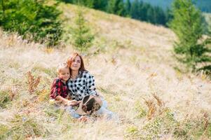 mamma abbracci un' poco figlia a il superiore di il montagna. quadrato. il concetto di famiglia, yoga, viaggio foto