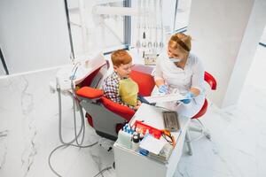 ragazzo soddisfatto con il servizio nel il dentale ufficio. concetto di pediatrico dentale trattamento foto