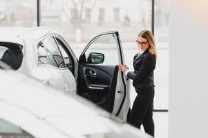 bellissimo giovane donna acquista un' auto nel il concessionaria salone. foto