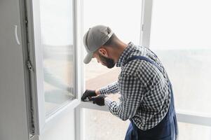 lavoratore installazione plastica finestra in casa foto