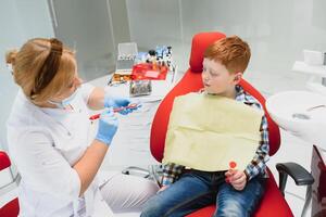 ragazzo soddisfatto con il servizio nel il dentale ufficio. concetto di pediatrico dentale trattamento foto